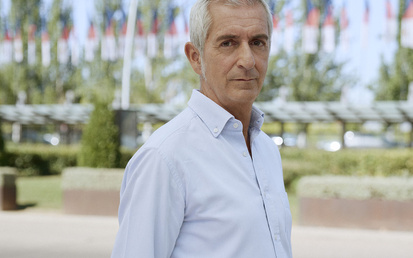 Rewind Ambassador Santiago Quiroga walking in front of a short hedge wall with trees in the background